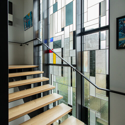 Ensemble de vitraux modernes sur mesure de 40 m² dans une maison d’architecte en bord de mer Méditerranée, création d’Angéline Clermont maître verrier à Montpellier